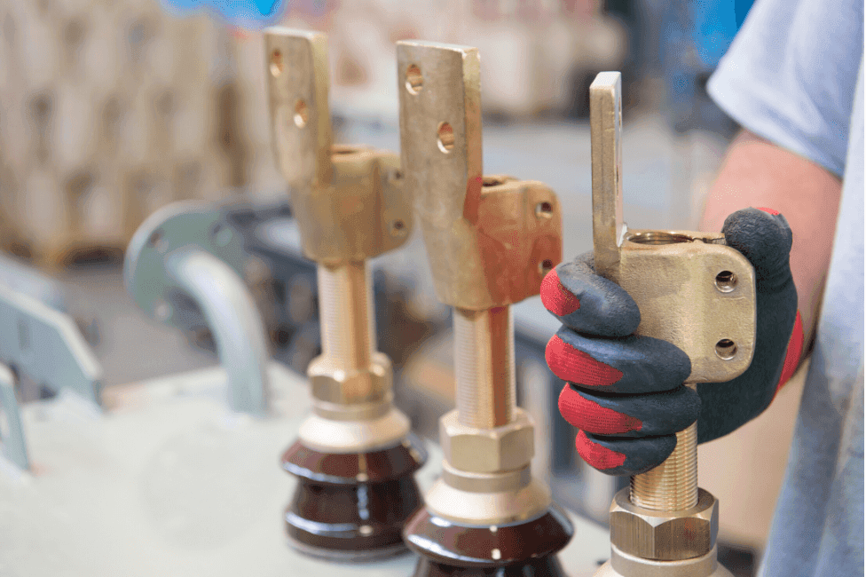 Technician assembling transformer bushings and brass terminals